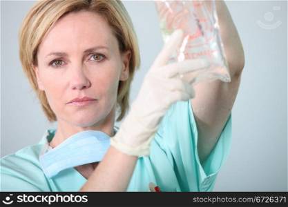 Hospital nurse attending to a drip bag