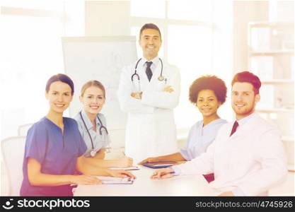 hospital, profession, medical education, people and medicine concept - group of happy doctors meeting on presentation or conference at hospital