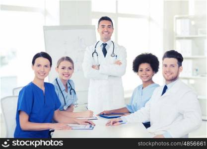 hospital, profession, medical education, people and medicine concept - group of happy doctors meeting on presentation or conference at hospital