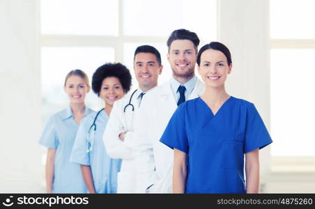 hospital, profession, people and medicine concept - group of happy doctors at hospital