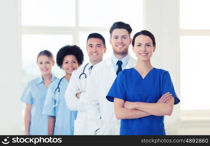 hospital, profession, people and medicine concept - group of happy doctors at hospital