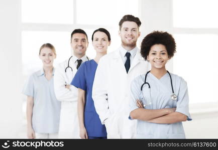 hospital, profession, people and medicine concept - group of happy doctors at hospital