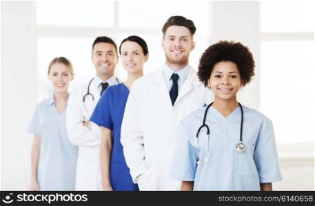 hospital, profession, people and medicine concept - group of happy doctors at hospital