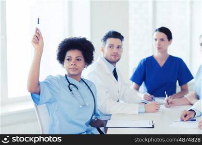 hospital, profession, people and medicine concept - group of happy doctors meeting and asking questions on conference at hospital
