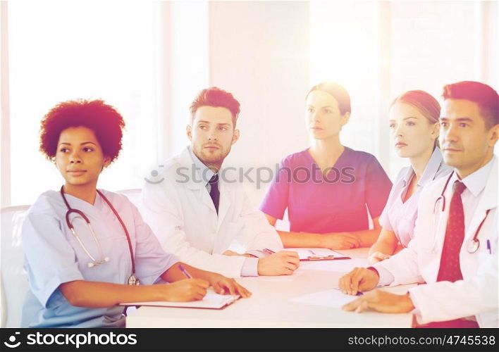 hospital, profession, people and medicine concept - group of happy doctors meeting on conference at hospital