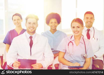 hospital, profession, people and medicine concept - group of happy doctors on seminar in lecture hall at hospital