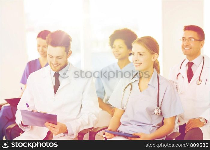 hospital, profession, people and medicine concept - group of happy doctors on seminar in lecture hall at hospital