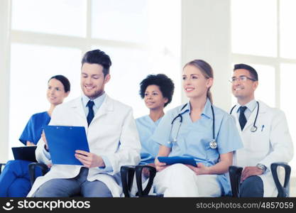 hospital, profession, people and medicine concept - group of happy doctors on seminar in lecture hall at hospital