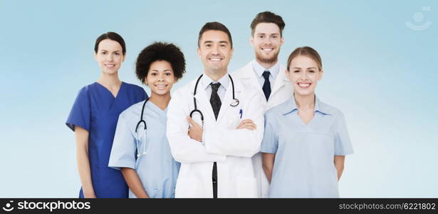 hospital, profession, people and medicine concept - group of happy doctors over blue background