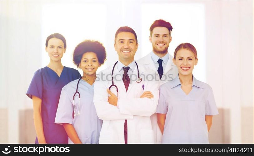 hospital, profession, people and medicine concept - international group of happy doctors at hospital
