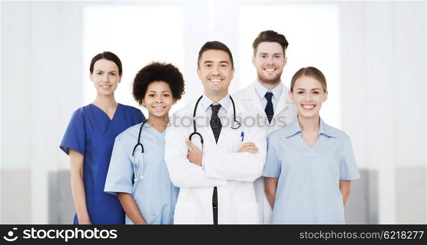 hospital, profession, people and medicine concept - international group of happy doctors at hospital