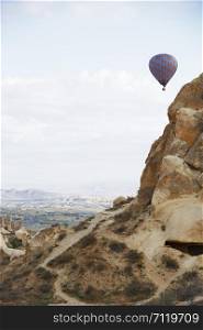 Hot air balloon flying over the rocky land. Cappadocia, Turkey