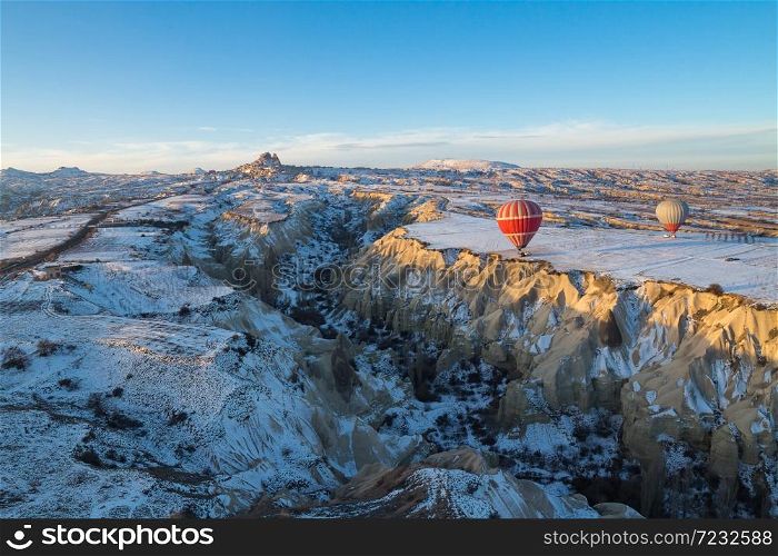 Hot air balloons fly over Cappadocia in winter, Goreme, Turkey.. Hot air balloons fly over Cappadocia.