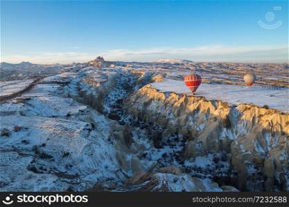 Hot air balloons fly over Cappadocia in winter, Goreme, Turkey.. Hot air balloons fly over Cappadocia.
