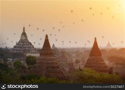 Hot air balloons flying over ancient pagodas with beautiful sunr. Hot air balloons flying over ancient pagodas with beautiful sunrise sky at Bagan, Myanmar. Asia travel destination.
