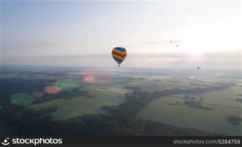 hot air balloons flying over river and field