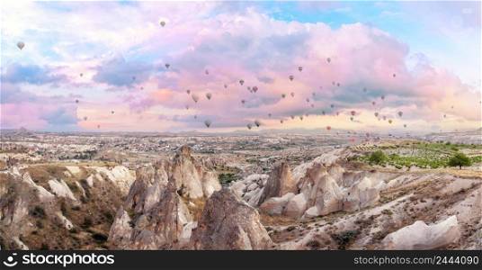Hot air balloons in the pink morning sky over Cappadocia. Panorama. Goreme, Turkey. Hot air balloons in pink morning sky over Cappadocia