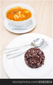 hot and sour soup with Brown rice in white plate (Selective Focus at rice)