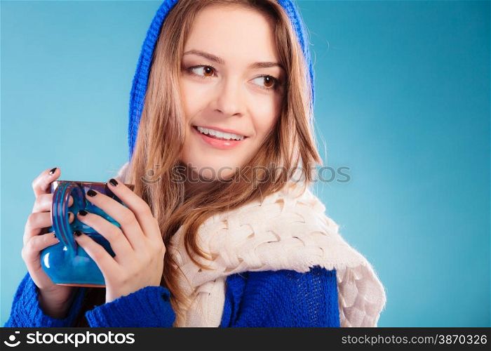 Hot beverage. Closeup teen girl holding blue mug with drink tea or coffee. Woman warming herself