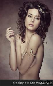hot brunette woman posing with fashion accessory, cute curly hair-style and naked body. She covering her breast and looking in camera