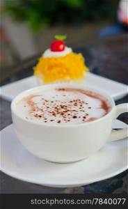 hot cappuccino in white coffee cup and sweet cake