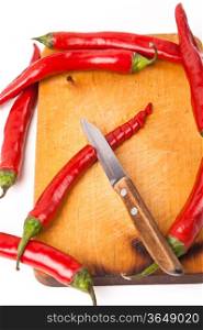 hot capsicum chili pepper and knife on wooden board
