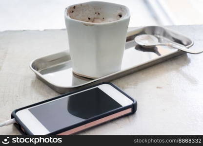 Hot chocolate cup and smart phone, stock photo