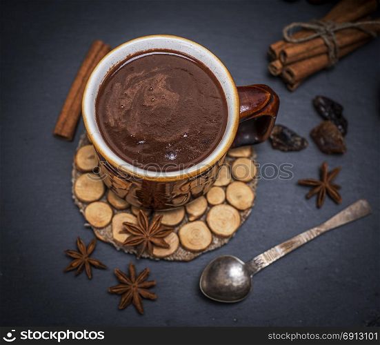 hot chocolate in a brown mug on a black background, top view