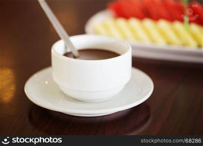 hot chocolate in cup with fruit background