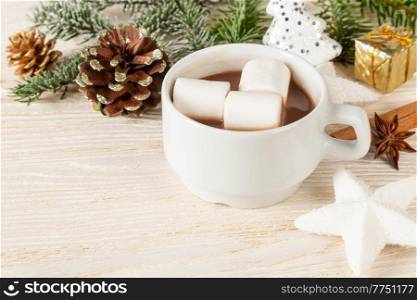 Hot chocolate or cocoa drink with marshmallow in a white cup and decorations on a wooden background. Christmas and new year traditional food. 
