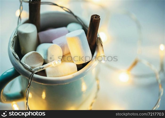 hot chocolate with marshmallow and Christmas lights cozy winter drink