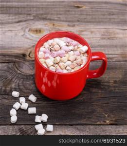 hot chocolate with marshmallow in a red ceramic mug, close up