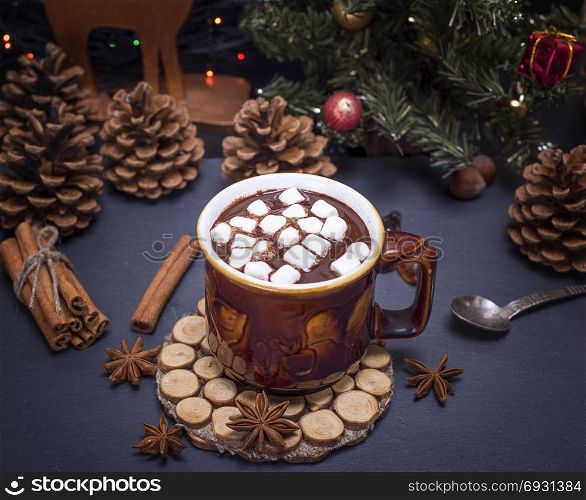 hot chocolate with marshmallows in a brown mug on a black background, top view