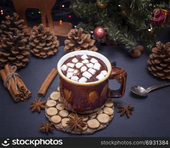 hot chocolate with marshmallows in a brown mug on a black background, top view