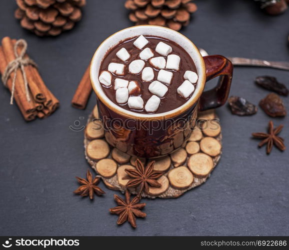 hot chocolate with white marshmallow slices in a brown ceramic mug, top view