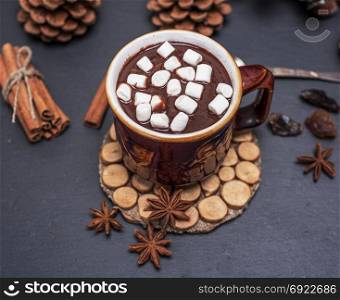hot chocolate with white marshmallow slices in a brown ceramic mug, top view