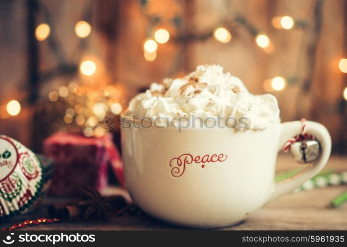 Hot cocoa in christmas mug with whipped cream on rustic wooden background