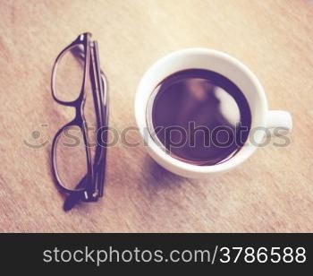 Hot coffee and eyeglasses with retro filter effect