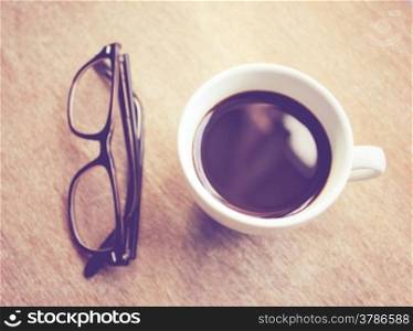 Hot coffee and eyeglasses with retro filter effect