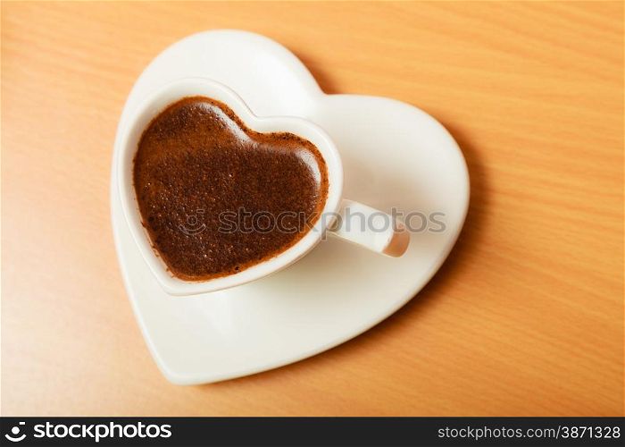 Hot coffee beverage in heart shaped cup mug on wooden board. Caffeine energy.. Coffee in heart shaped cup mug. Caffeine energy.