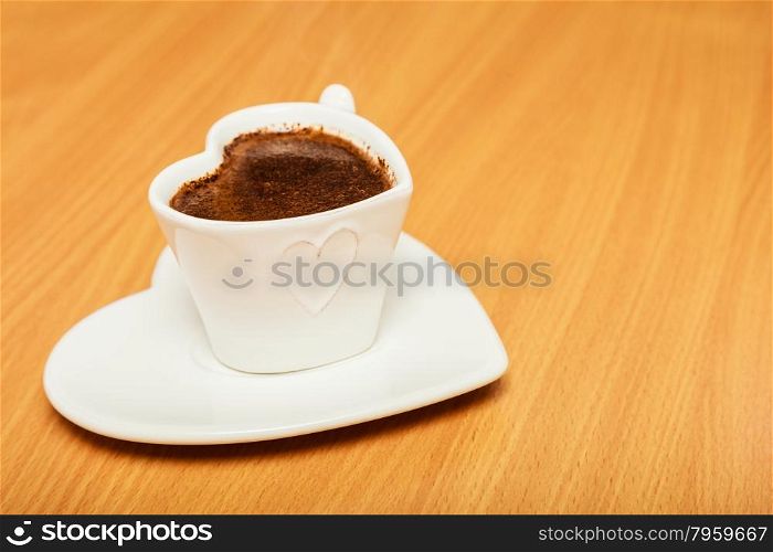 Hot coffee beverage in heart shaped cup mug on wooden board. Caffeine energy.. Coffee in heart shaped cup mug. Caffeine energy.
