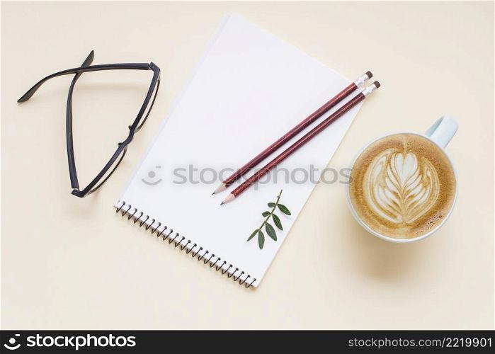 hot coffee cappuccino latte art eyeglasses pencils white spiral notepad