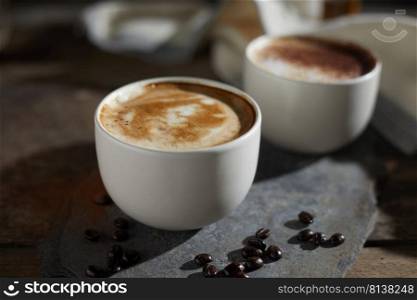 Hot coffee cup and coffee beans on wooden table. 