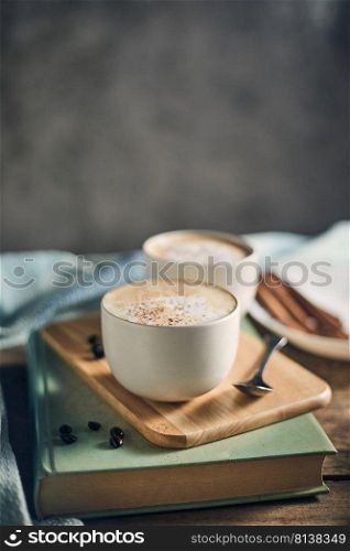 Hot coffee cup and coffee beans on wooden table. 