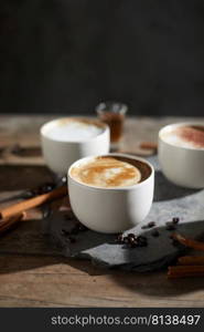 Hot coffee cup and coffee beans on wooden table. 