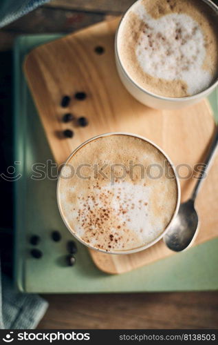 Hot coffee cup and coffee beans on wooden table. 