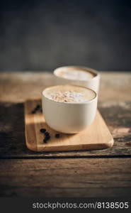 Hot coffee cup and coffee beans on wooden table. 