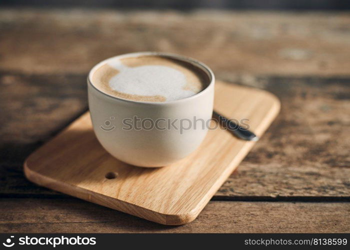 Hot coffee cup and coffee beans on wooden table. 