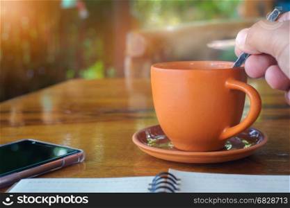 Hot coffee in the morning with smartphone and notebook.Vintage style