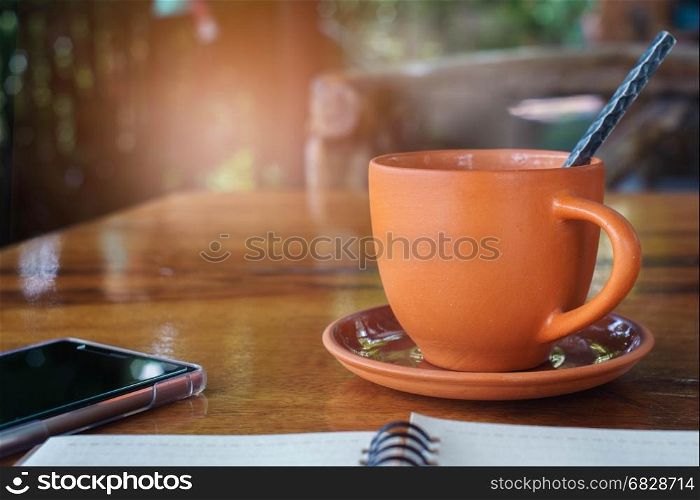 Hot coffee in the morning with smartphone and notebook,Vintage Style.